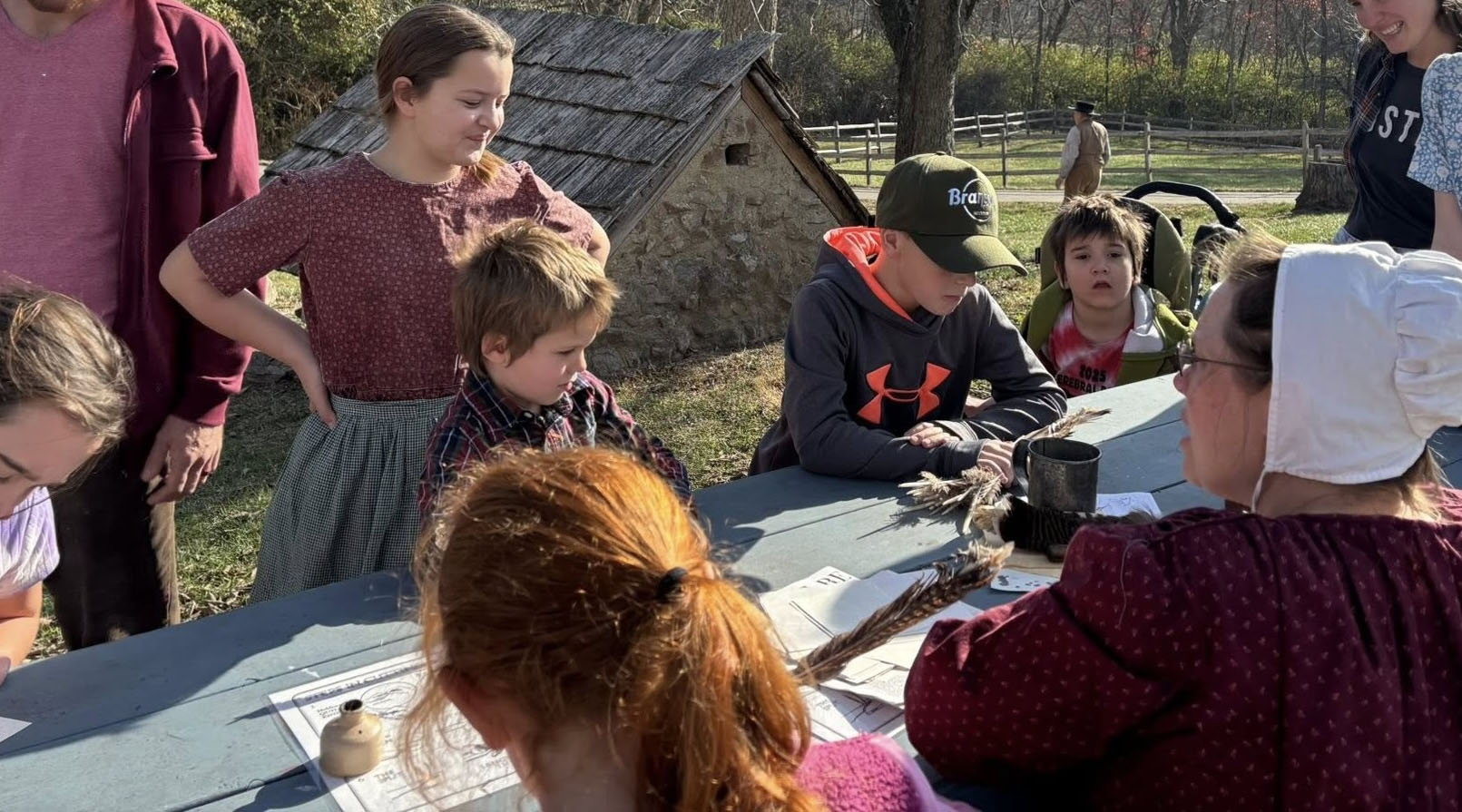Children participating in a hands-on activity with a costumed interpreter